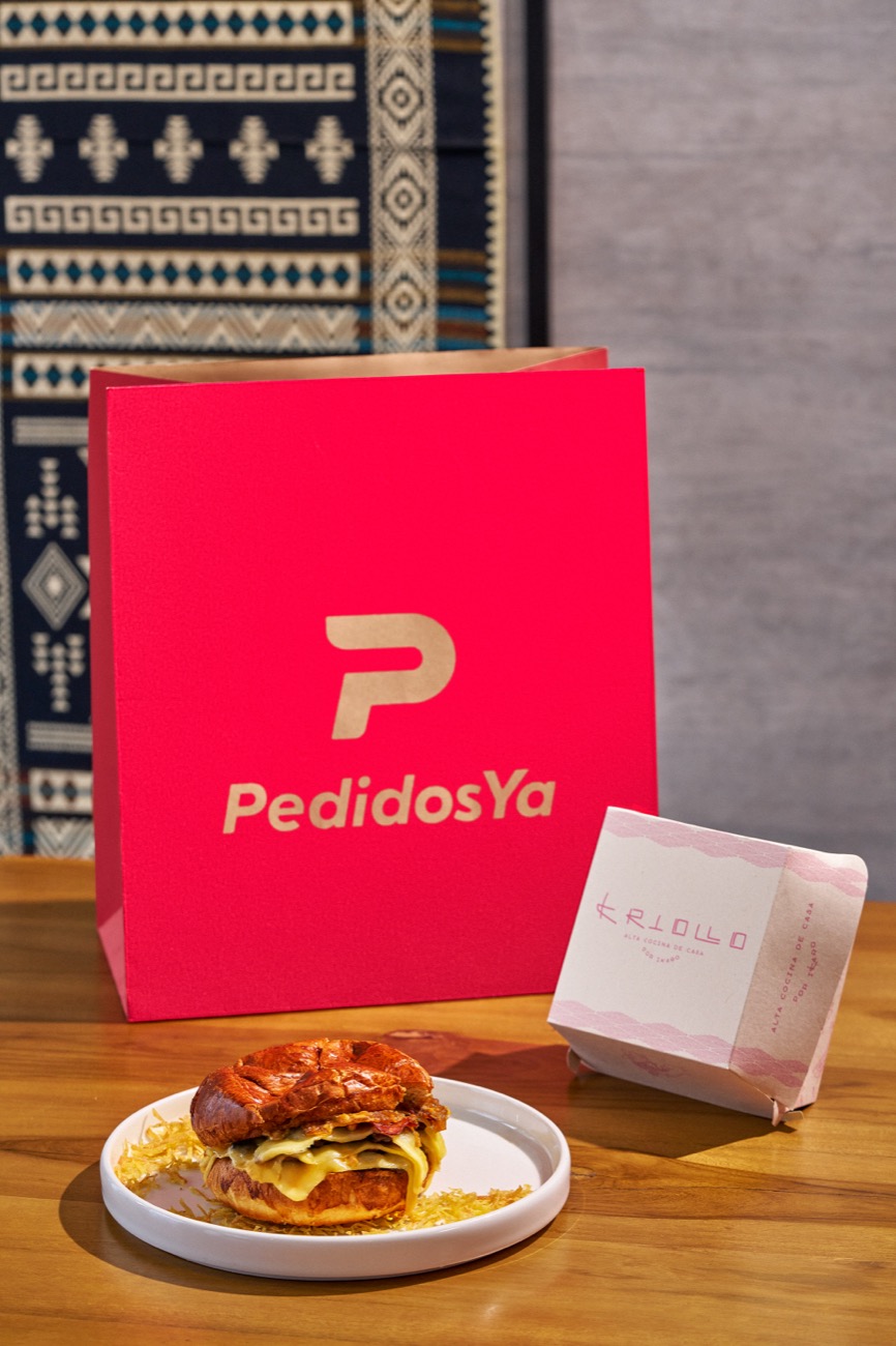 Bolsa PedidosYa junto a sándwich gourmet y empaque Kriollo