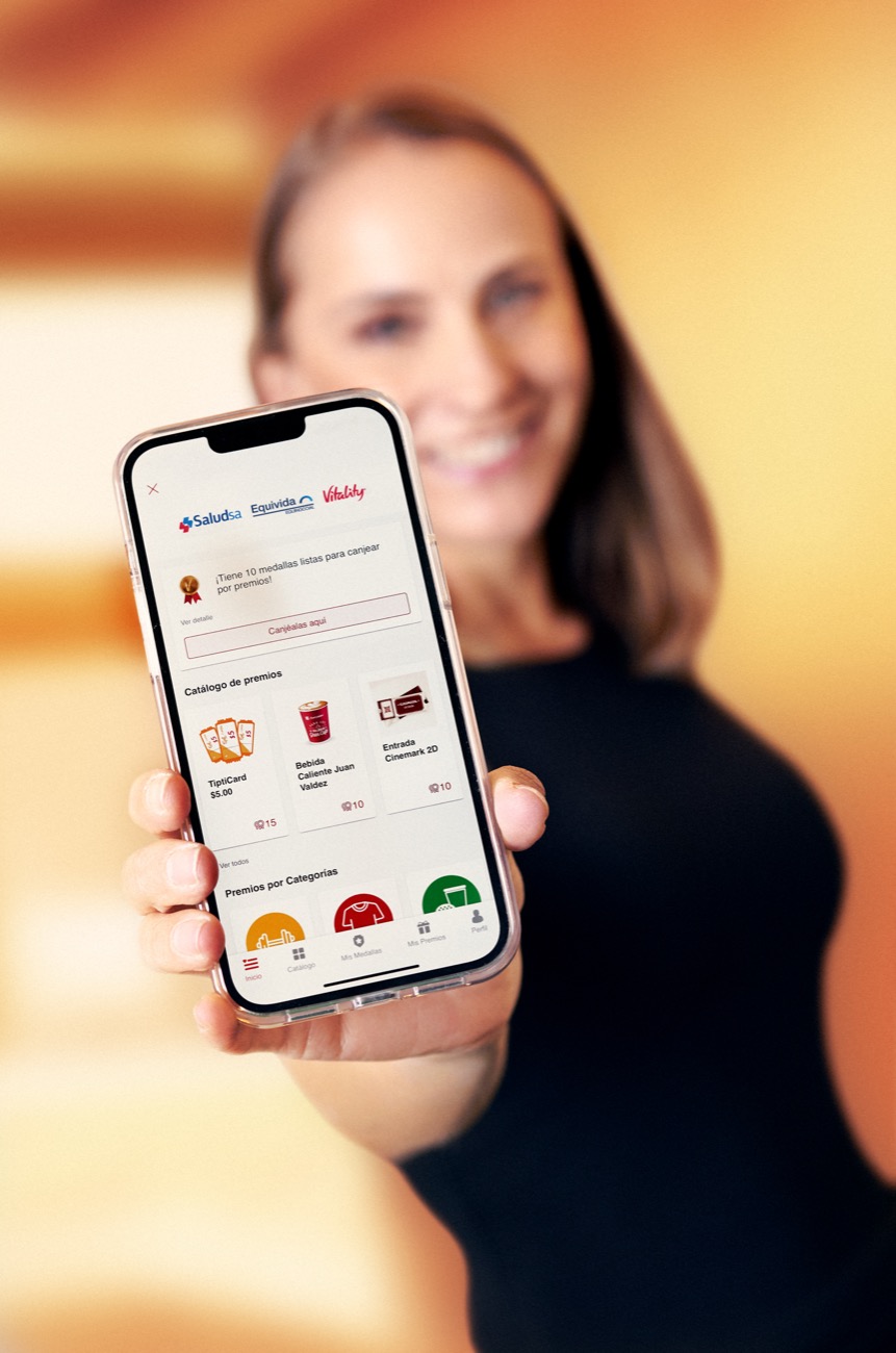 Mujer mostrando la app de premios de SaludSA, Equivida y Vitality